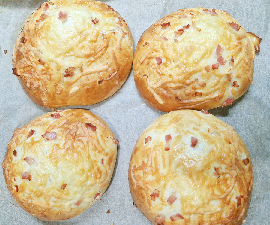 Świeżo upieczone bułki do burgera drwala. Na zdjęciu 4złociste i chrupiące z zapieczonym na górze boczkiem i serem