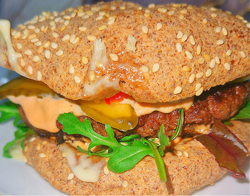 Zbliżenie na złocistą bułkę upieczoną na bazie mąki migdałowej. Podana na jasnym tle