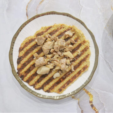 Zbliżenie na chrupiący placek z kiszonej kapusty polany wyrzoskami.