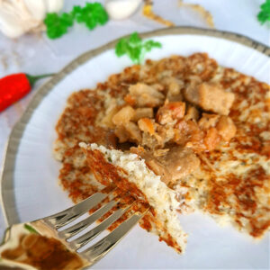 Zbliżenie na keto placki bez mąki i ziemniaków na bazie kalafiora podanych z Wiślańskimi wyrzoskami.