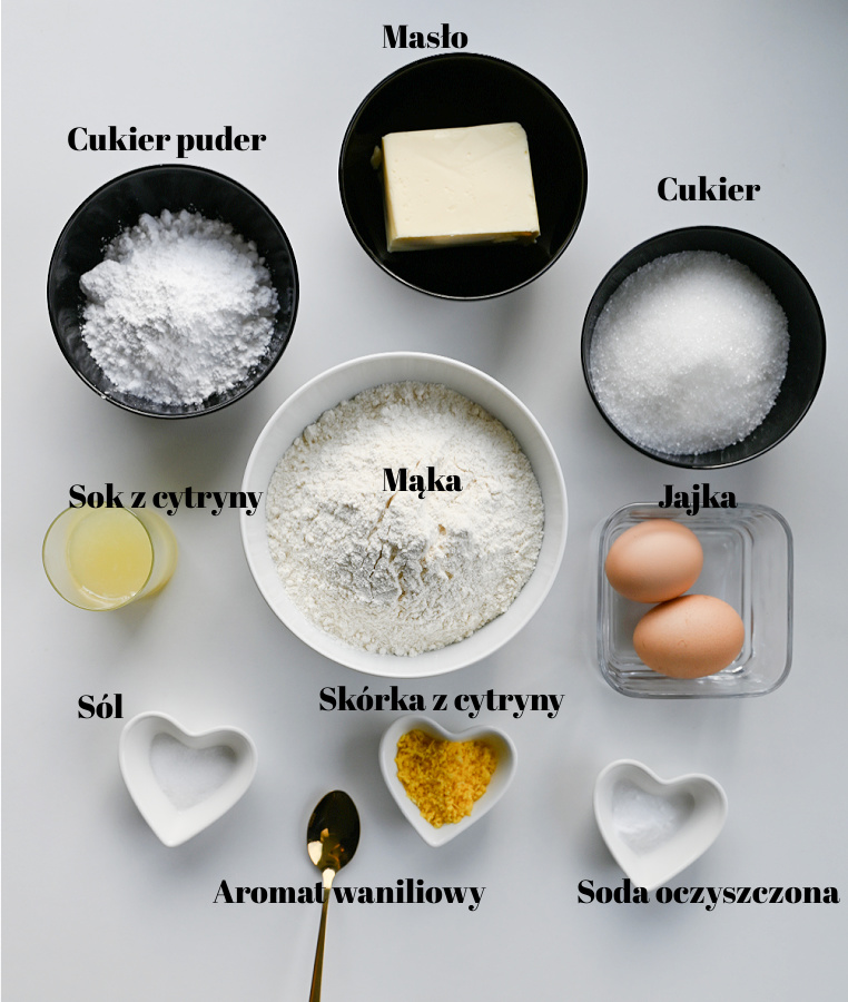 Składniki na ciasteczka cytrynowe popękane ułożone na białym blacie widok z góry
