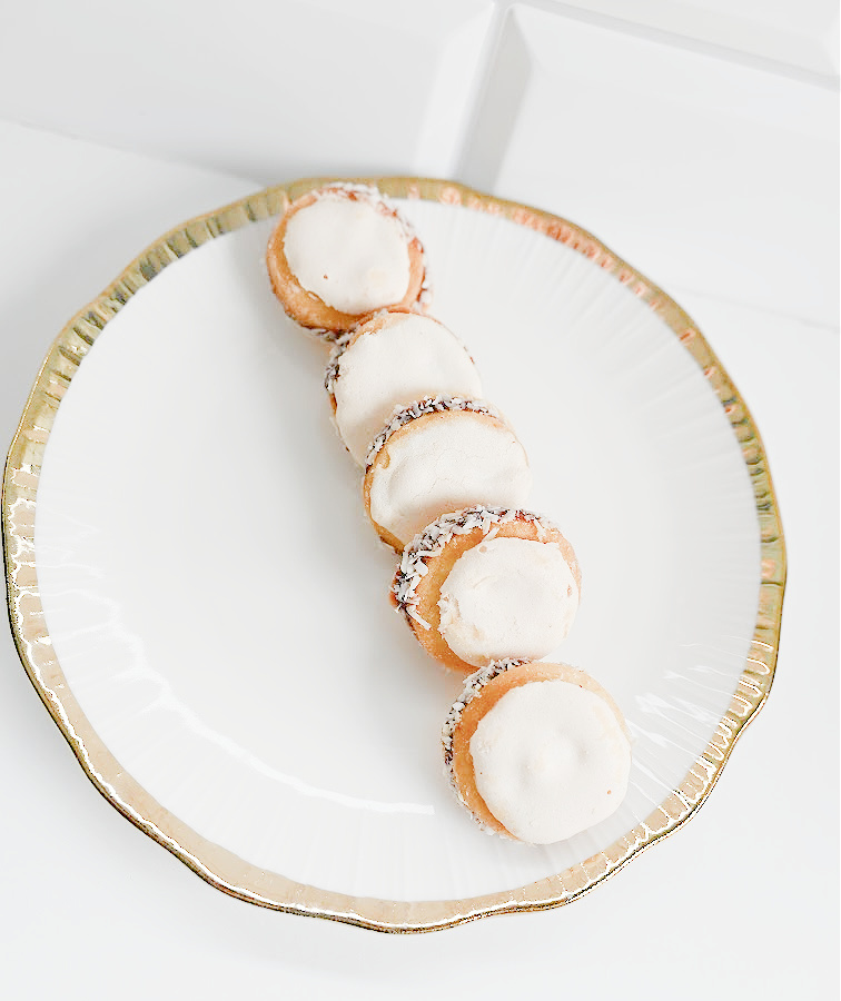 Ciasteczka aspirynki podane na białym talerzyku ze złotą obwódką