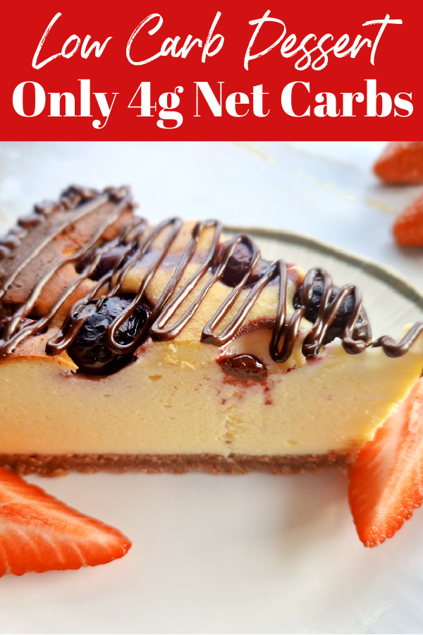 Close-up of a slice of keto blueberry cheesecake drizzled with chocolate, served with strawberries. Text overlay: Low Carb Dessert Only 4g Net Carbs.