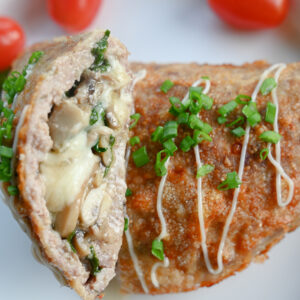 Zdjęcie główne kwadratowe. Gotowe kieszonki z mięsa mielonego podane na talerzu z dodatkiem warzyw.