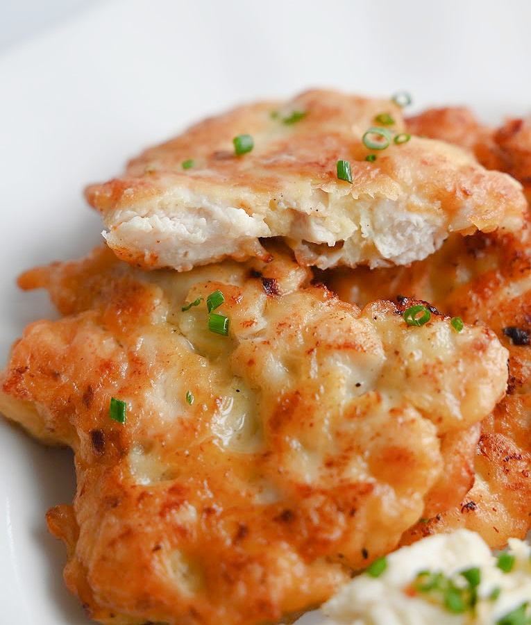 Przekrojony kotlet siekany z kurczaka pokazujący soczyste wnętrze.