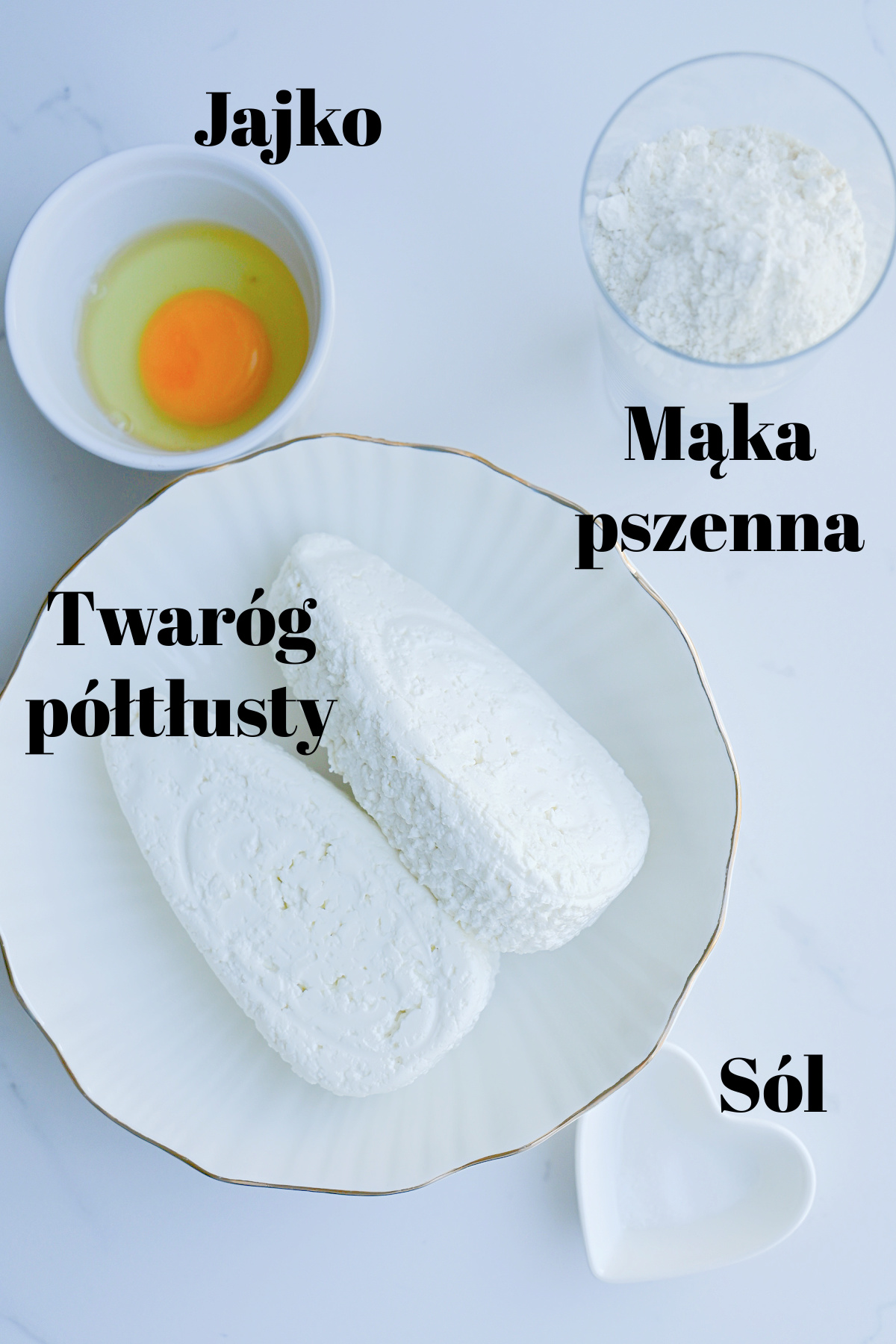 Składniki na kluski leniwe z napisami: twaróg półtłusty, mąka pszenna, jajko i sól na białym tle.